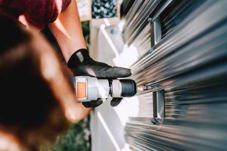 Industrial details of working construction man, using screwdriverの写真素材