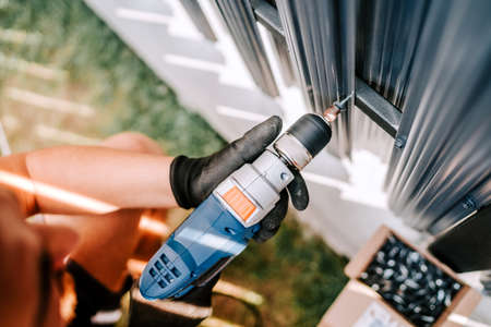 construction worker working with an electric screwdriver on the construction siteの写真素材