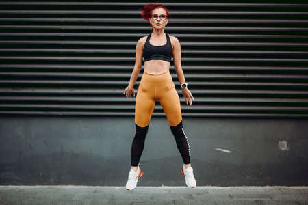 Fitness woman exercising and jumping during workout