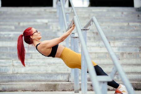 Active fit woman stretching and relaxing muscles after hard workout. Fitness cross fit and sports...