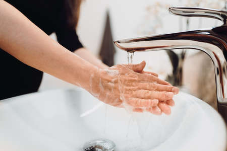 Close up details of female, woman washing hands at home . Hygiene and body cleaning concept detail