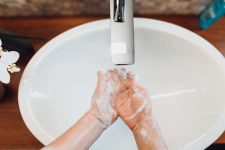 Close up details of female, woman washing hands at home . Hygiene and body cleaning concept detailの写真素材