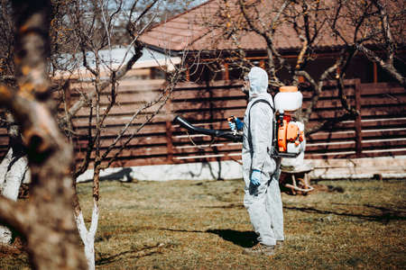 Agriculture worker concept. Farmer spraying organic pesticidesの写真素材