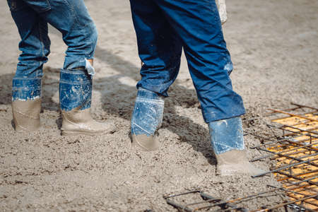 close up details of worker workwear during cement pouring