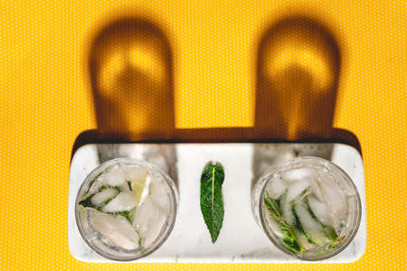Top view of two perfect mojito cocktails on vintage yellow dots background and hard shadowsの写真素材