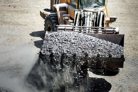 Machinery industry -  heavy construction machinery in open pit ore mine - wheel loader transports...
