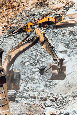 Track-type excavator during rock moving works at open-pit mining, huge ore quarry