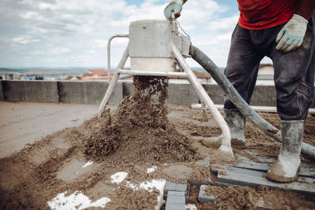 Laborer working on a floor screed on roof terraceの写真素材