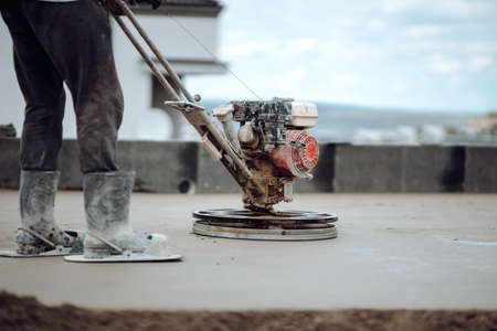 Helicopter concrete floor finishing on construction site. Construction worker finishing concrete...