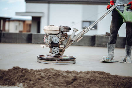 Helicopter concrete floor finishing on construction site. Construction worker finishing concrete screed with power trowel machineの写真素材