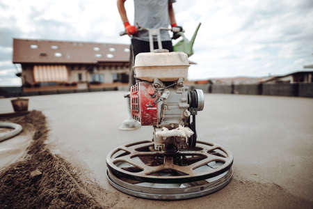 Laborer working on a floor screed on roof terraceの写真素材