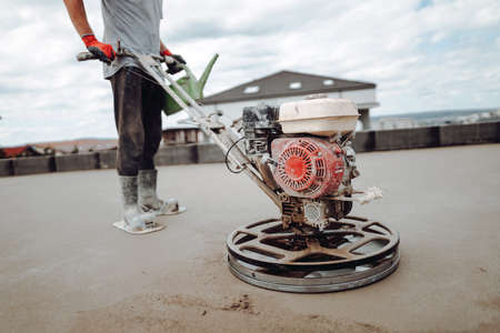 Laborer working on a floor screed on roof terraceの写真素材