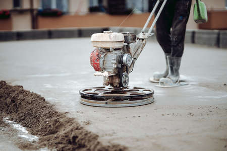 Laborer working on a floor screed on roof terrace