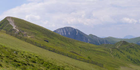 hiking path on sloped hills with a view on mountain ridges goldeckの写真素材