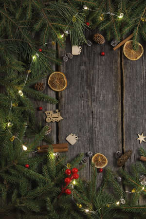 A part of christmas decoration frame on wooden background with different elements of food and some wooden christmas toysの写真素材