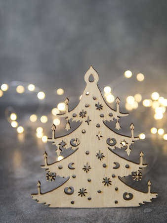 Stylish Christmas handmade tree made of wood on gray background with glowing lights. Overhead of Christmas New Year holiday background. Selective focus, place for textの写真素材
