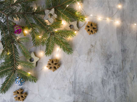 Christmas card at old vintage board with branches christmas tree, wooden stars, Ginger cookies like snowflakes, colored balls and glowing lights. New Year background.Place for text, top view, flat layの写真素材