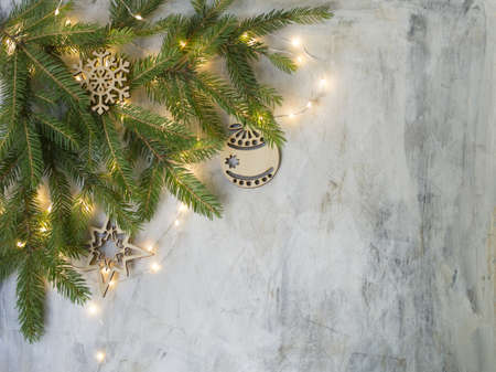 Christmas card at old vintage board with branches christmas tree, wooden snowflakes and balls and glowing lights. New Year background. Place for text, top view, flat layの写真素材
