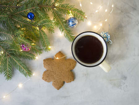 Christmas background with Gingerbread cookies, cup of tea. Cozy evening, Christmas decorations, colored balls and lights garlands. New Year card. Copy space, selective focus, from aboveの写真素材