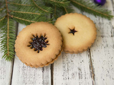 Christmas cookies with spices on wooden table with fir tree branches decorated with spruce balls. Festive New Years atmosphere. Selective focus, copy spaceの写真素材