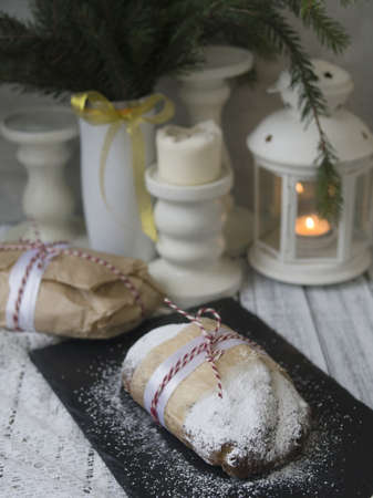Whole Christmas Stollen with raisins, dried apricots, dried cherries, nuts and candied fruits in sugar glaze on a festive background. Delicious festive Christmas dessert. Copy space, selective focusの写真素材