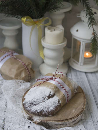 Whole Christmas Stollen with raisins, dried apricots, dried cherries, nuts and candied fruits in sugar glaze on a festive background. Delicious festive Christmas dessert. Copy space, selective focusの写真素材