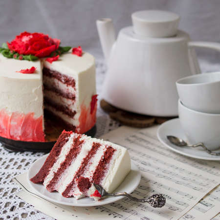 Red Velvet Cake decorated with buttercream rose on table with lace fabric. It is suitable for...