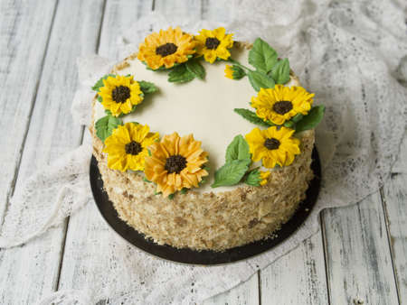 Napoleon cake with vanilla cream, decorated with buttercream flowers - sunflowers. Vintage style. Wooden background,lace napkin.Sweet gift for Valentine's Day,Women's Day,Birthday.Copy space,close upの写真素材