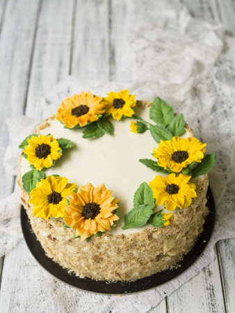 Napoleon cake with vanilla cream, decorated with buttercream flowers - sunflowers. Vintage style. Wooden background,lace napkin.Sweet gift for Valentine's Day,Women's Day,Birthday.Copy space,close upの写真素材