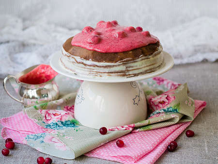 Chocolate crepe cake with with curd cream and cranberry topping on a stand. Pancake week. Sunday breakfast. Vintage. Copy space, selective focusの写真素材