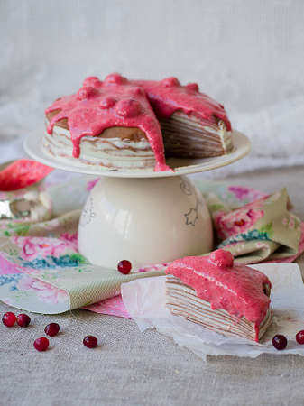Chocolate crepe cake with with curd cream and cranberry topping on a stand. Pancake week. Sunday breakfast. Vintage. Copy space, selective focusの写真素材