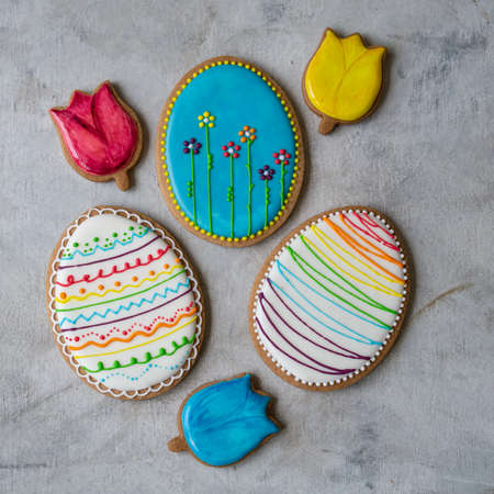 Happy family holiday, gingerbread easter bright cookies in form eggs. Festive cookies on gray...