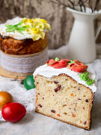 Easter cake kulich.Traditional sweet bread decorated meringue, yellow daffodils on gray background...