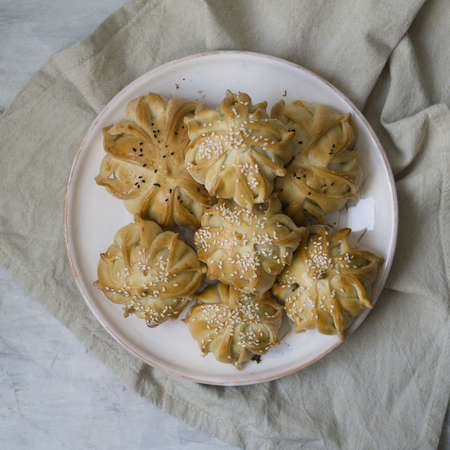 Interestingly shaped fresh meat mini pie. Delicious samosa pies with meat on plate on gray background. Menu, restaurant, recipe concept. Selected focus, close up, copy space.の写真素材
