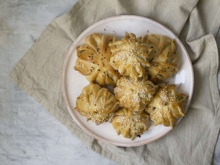 Interestingly shaped fresh meat mini pie. Delicious samosa pies with meat on plate on gray background. Menu, restaurant, recipe concept. Selected focus, close up, copy space.の写真素材