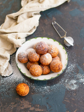 Beautiful breakfast. Cottage cheese donuts balls with sugar powder on a dark background. Close up. Copy spaceの写真素材