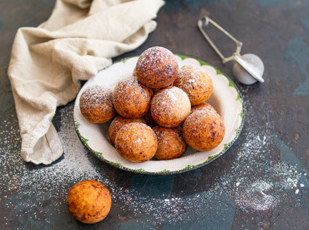 Beautiful breakfast. Cottage cheese donuts balls with sugar powder on a dark background. Close up. Copy spaceの写真素材