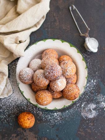 Beautiful breakfast. Cottage cheese donuts balls with sugar powder on a dark background. Close up. Copy spaceの写真素材