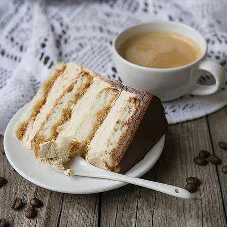Tiramisu. A slice of a traditional Italian dessert on a white plate and a cup of coffee on a marble table. Selective focus. Copy space.の写真素材