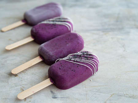 Healthy homemade raw vegan blueberry ice cream on stick with cashew, healthy vegetarian diet vegan raw fruit organic delicious dessert, dairy free, gluten free.Close up, copy space,top view.の写真素材