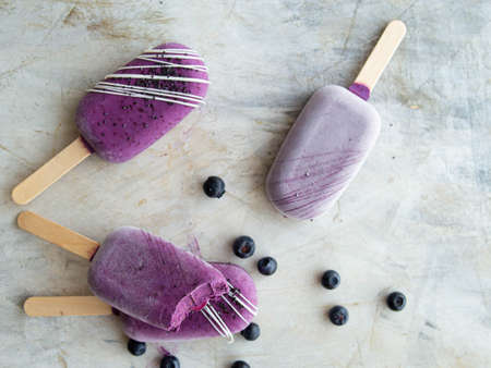 Healthy homemade raw vegan blueberry ice cream on stick with cashew, healthy vegetarian diet vegan raw fruit organic delicious dessert, dairy free, gluten free.Close up, copy space,top view.の写真素材