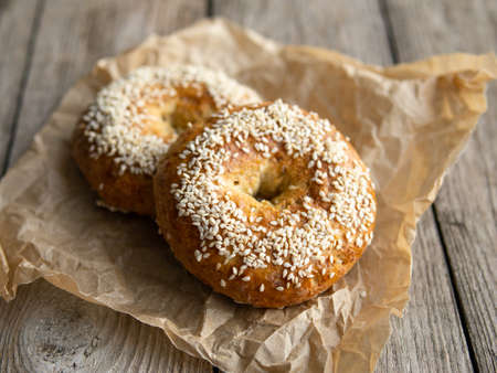 Fresh cheese donuts with sesame seeds on a wood background with metal white cup of coffee. Heathy food, diet, breakfast, lunch. Top view with copy space. retro, vitage.の写真素材