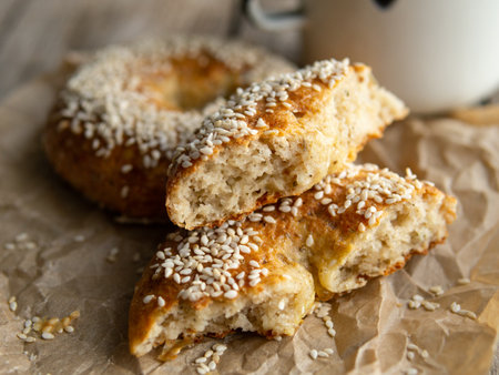 Fresh cheese donuts with sesame seeds on a wood background with metal white cup of coffee. Heathy food, diet, breakfast, lunch. Top view with copy space. retro, vitage.の写真素材