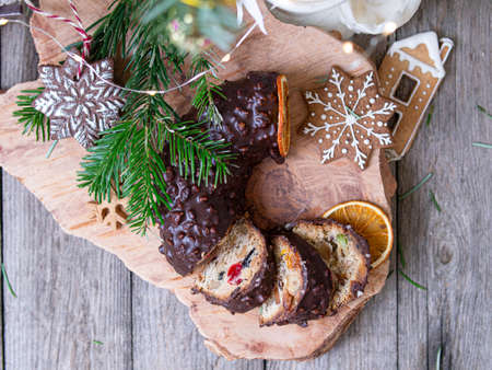 Traditional homemade christmas cake holiday dessert with chocolate glaze in new year tree decorations frame on vintage wooden table background. Rustic style. Top view.の写真素材