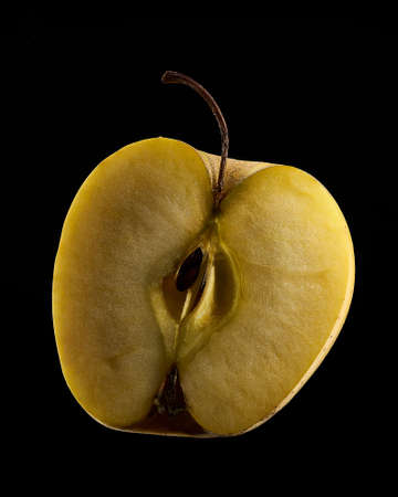 Half golden apple. Close up photo. Black background.の写真素材