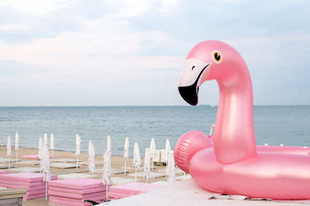 inflatable pink funny flamingo against the sky, the symbol of the beach season, copy spaceの写真素材
