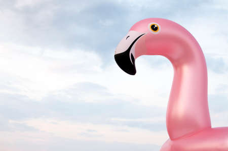 inflatable pink funny flamingo against the sky, the symbol of the beach season, copy spaceの写真素材