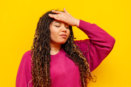 sad plump african american upset woman shows facepalm on yellow isolated background, big plus size girl with dreadlocks suffers from failの写真素材