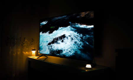 Working TV in a dark roomの写真素材