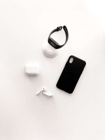 Fitness watches and wireless headphones lie on a beautiful white table.の写真素材